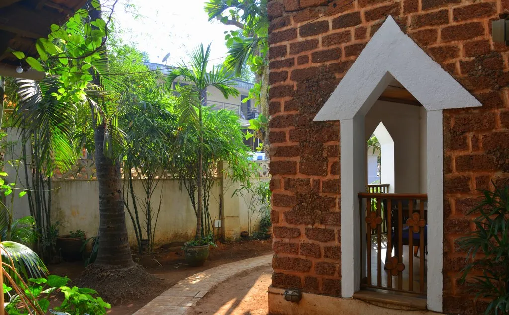 Garden path with palms and a laterite arch at Cavala