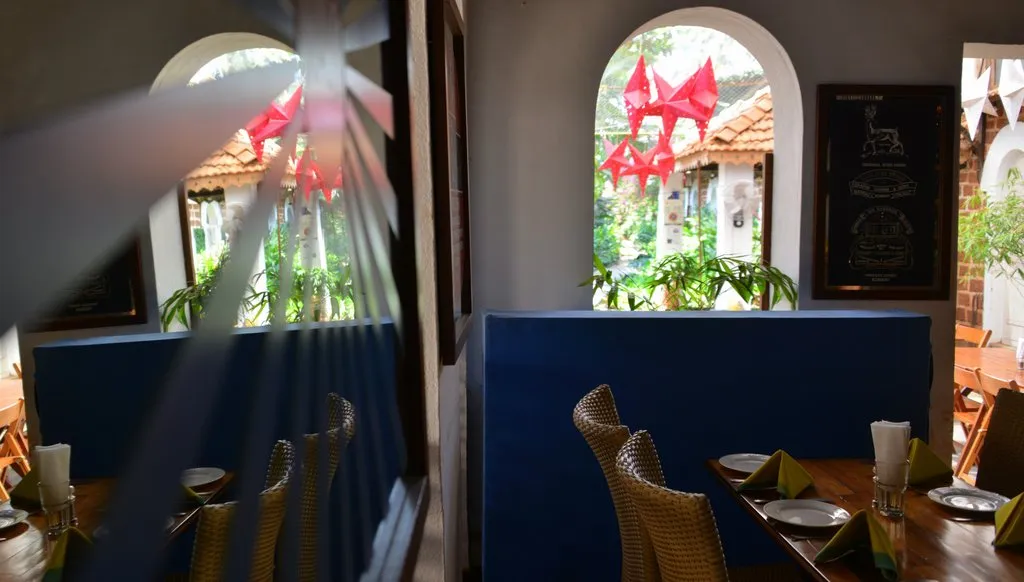 Restaurant interior with laterite arches and star lanterns at Cavala