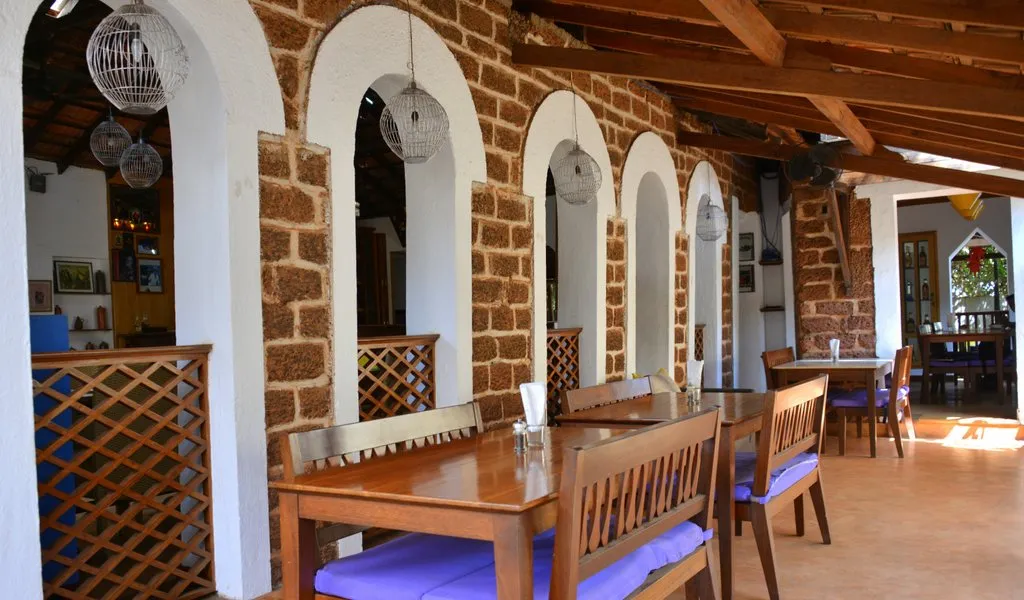 Dining veranda with arched laterite windows at Cavala