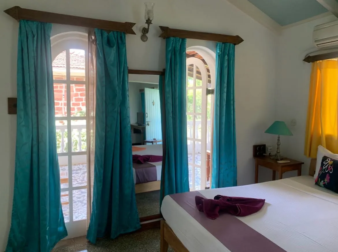 Bedroom with arched windows and teal drapes at Cavala, Baga