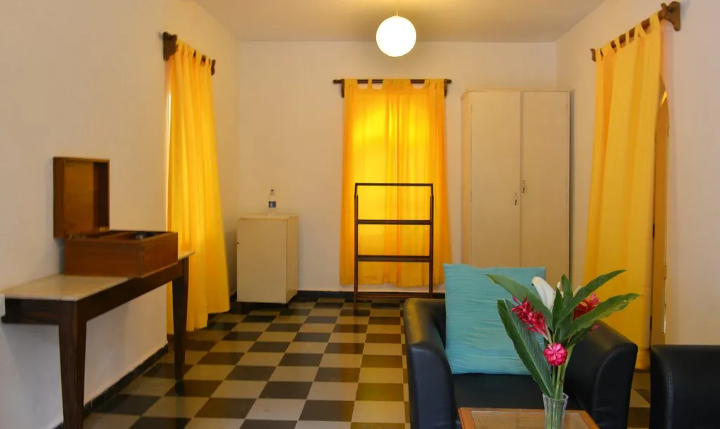 Room with a checkerboard floor and sunny drapes at Cavala