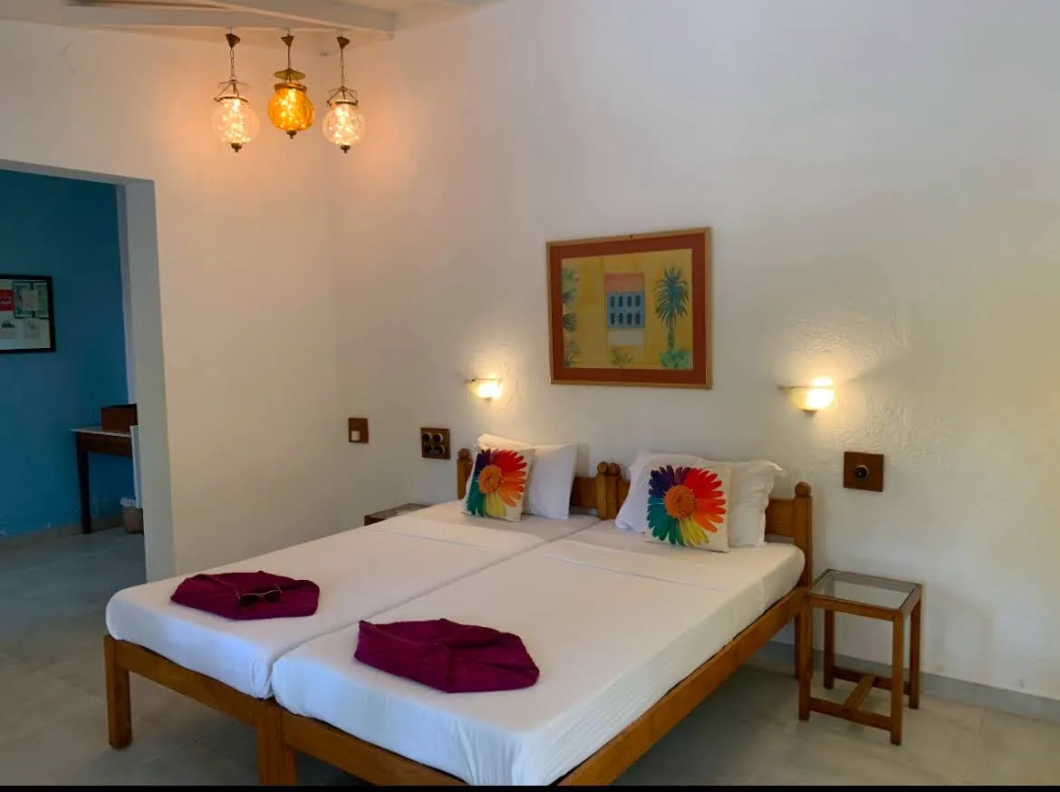 Twin room with hanging lanterns and framed art at Cavala