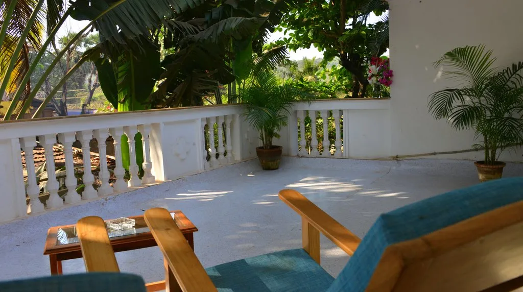 Private terrace with planter's chairs and tropical greenery at Cavala